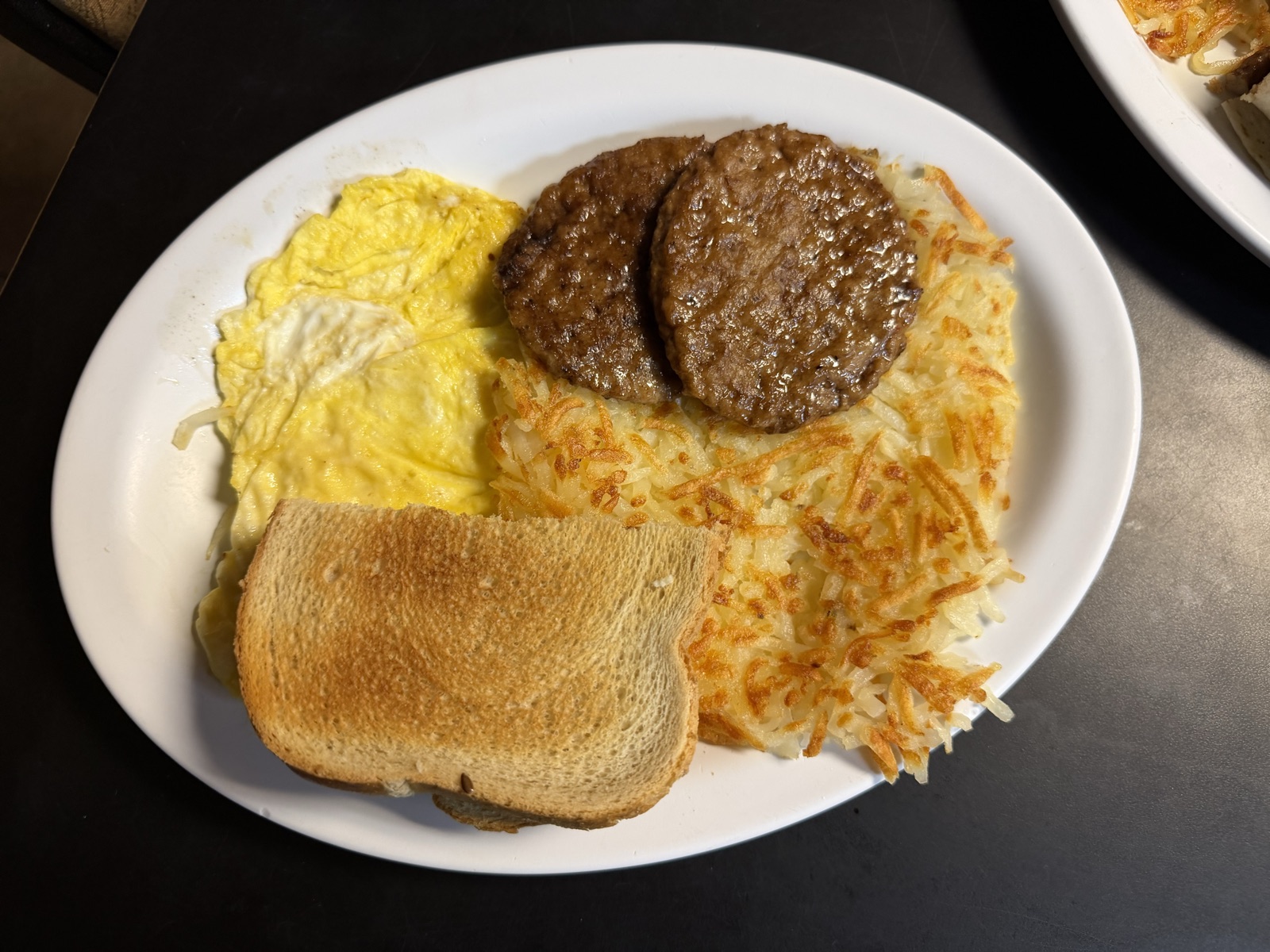 Scrambled eggs, sausage patties, hash browns and toast